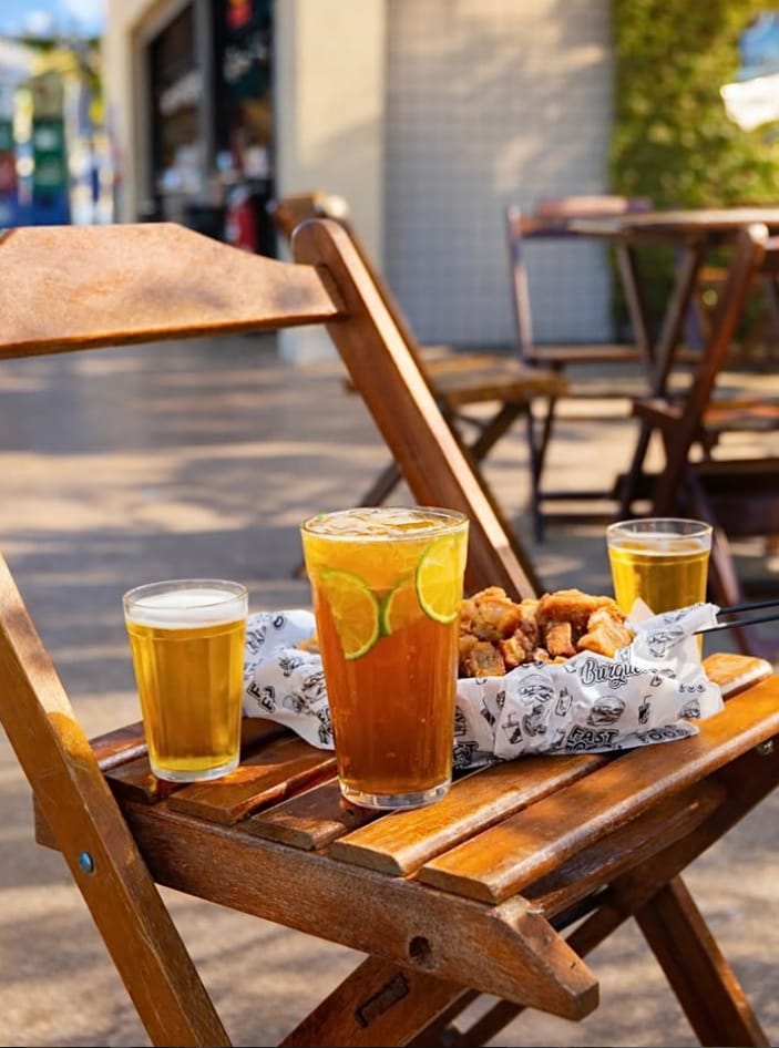 Chopp e petisco na cadeira de madeira ao entardecer no Santo Grau