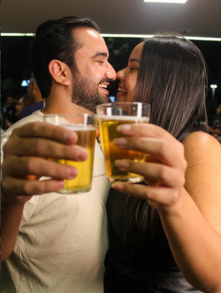 Casal brindando com chopp gelado numa noite no Santo Grau